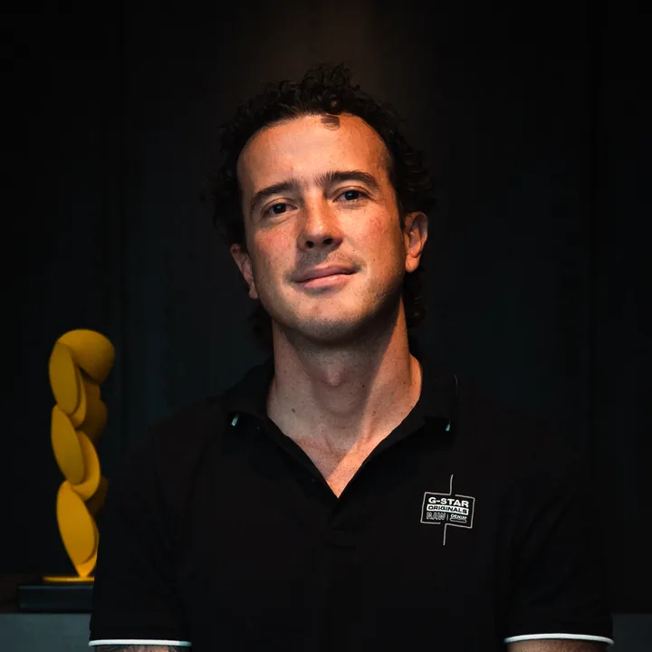 Nicolás Mondragón, autor de Contra el Ruido, sonriendo con camiseta tipo polo negra sobre un fondo oscuro.